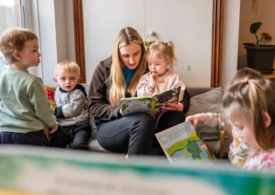 Children sharing a story with a practitioner at Monmouth Day Nursery
